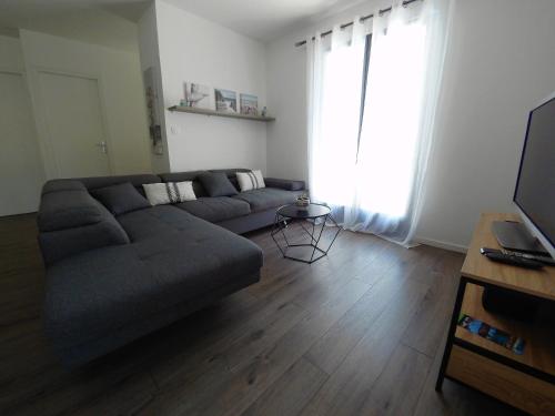 un salon avec un canapé et une grande fenêtre dans l'établissement Gîte à la campagne avec jacuzzi, à Avensan