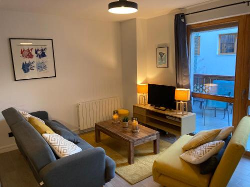 ein Wohnzimmer mit 2 Sofas und einem TV in der Unterkunft Label OR appartement spacieux proximité pistes in Les Deux Alpes