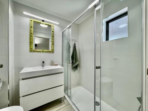 a bathroom with a shower and a sink and a mirror at The Olive Tree Vilamoura Centre in Vilamoura