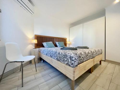 - une chambre avec un lit et une chaise blanche dans l'établissement The Olive Tree Vilamoura Centre, à Vilamoura
