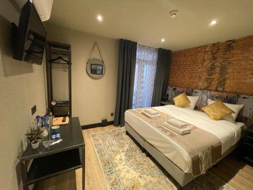 1 dormitorio con cama, espejo y mesa en BEAUTiQUE HOTEL CITY CENTRE, en Ámsterdam