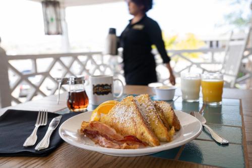 a plate of food with a sandwich and oranges on a table at Hotel El Rancho in Gallup