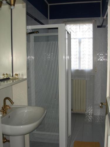 a white bathroom with a sink and a shower at La Corte Del Cavaliere Bed & Breakfast in Calderara di Reno