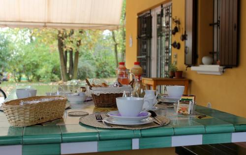 a table with cups and dishes on a green counter top at La Corte Del Cavaliere Bed & Breakfast in Calderara di Reno