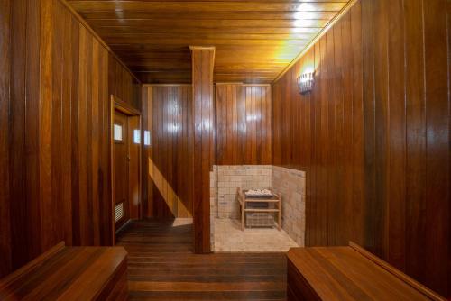 a room with a stone fireplace in a wooden wall at Laghetto Resort Golden Oficial in Gramado
