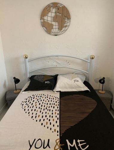 un lit avec un panneau qui me dit sur lui dans l'établissement Rez de villa avec place de parking et vue mer., à La Ciotat