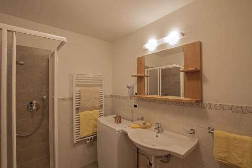 a bathroom with a sink and a shower and a mirror at Apartements Precalalt in La Villa