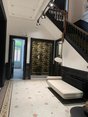 a living room with a couch and a staircase at Maison Mimerel Colodge in Roubaix