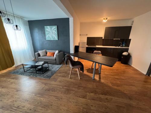 salon ze stołem i kanapą w obiekcie Mon Palmier Grand Appartement Parking Un-Séjour-à-Part w Metz