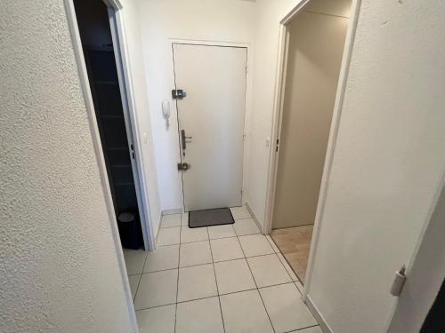 a hallway with a door and a tiled floor at Mon Palmier Grand Appartement Parking Un-Séjour-à-Part in Metz