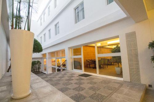 a large white building with a courtyard with a table at Tierra Viva Arequipa Plaza in Arequipa
