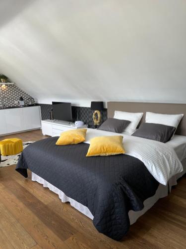 1 dormitorio con 1 cama grande con almohadas amarillas en Rooftop terrace suite, en Heist-op-den-Berg