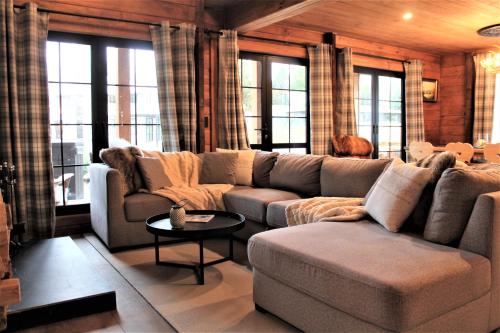 a living room with a large couch and windows at The Bavarian Chalet in Ohakune