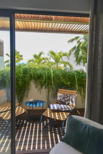 a patio with two chairs and a table on a balcony at Le Martin Boutique Hôtel in Cul de Sac