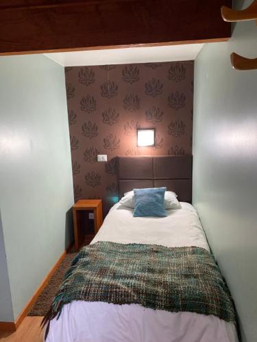 a bedroom with a bed with a blue pillow on it at Cabañas El Galo in Panguipulli