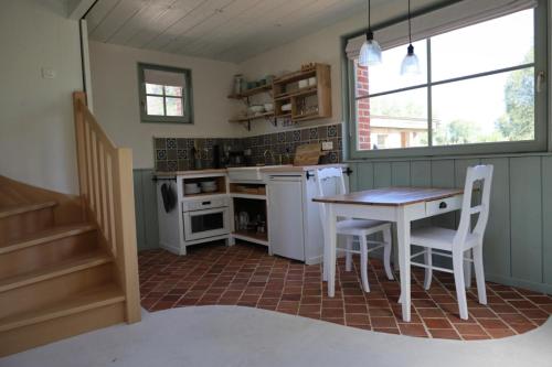 a kitchen with a table and chairs in a room at Les Jardins d'Olus in Wandignies-Hamage