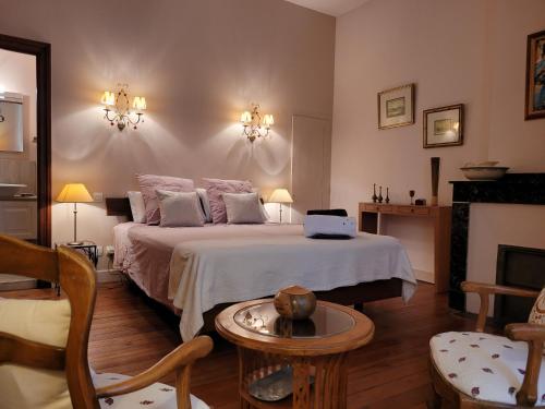 1 dormitorio con 1 cama grande y 1 mesa en Demeure vigneronne de charme Pays CATHARE Carcassonne Blomac Jacuzzi, en Blomac