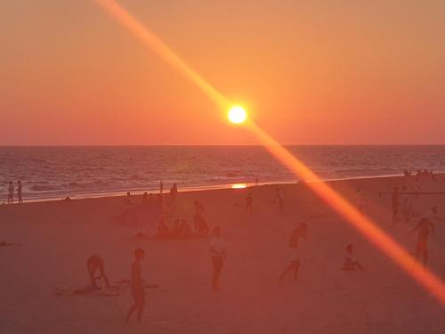 a group of people on the beach at sunset at Casa DOÑANA in Matalascañas
