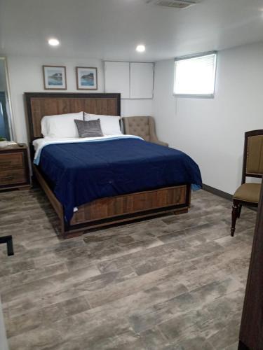 1 dormitorio con 1 cama grande con manta azul en Toronto Furnished Living- Niagara Falls, en Niagara Falls