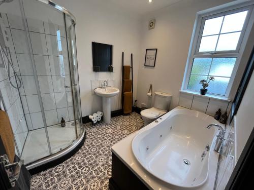 a bathroom with a tub and a toilet and a sink at Contemporary & Chic inner terrace 5 mins from Barnsley town centre in Barnsley