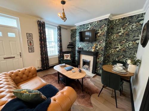 a living room with a couch and a fireplace at Contemporary & Chic inner terrace 5 mins from Barnsley town centre in Barnsley