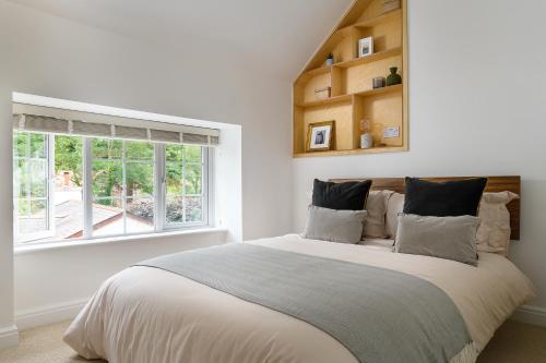 een witte slaapkamer met een groot bed en een raam bij Heathercliffe Cottage, Snowdonia National Park in Penmaen-mawr