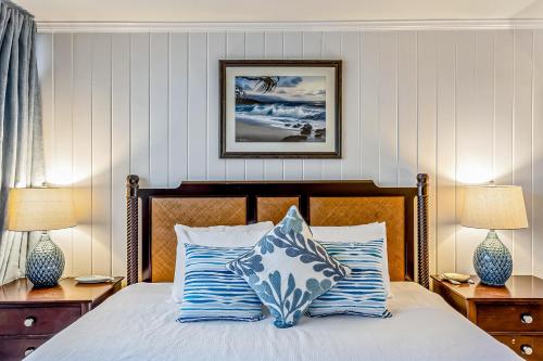 a bedroom with a bed with blue and white pillows at Polynesian Shores 118 in Kahana