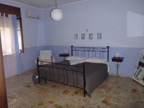 um quarto com uma cama e uma parede azul em Casa Bianca Grande em Rodi