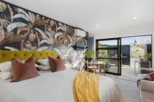 a bedroom with a large bed with a yellow headboard at Matamata Lodge in Matamata