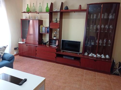 a living room with a entertainment center with a tv at Casa Yaya Felisa in Lledó
