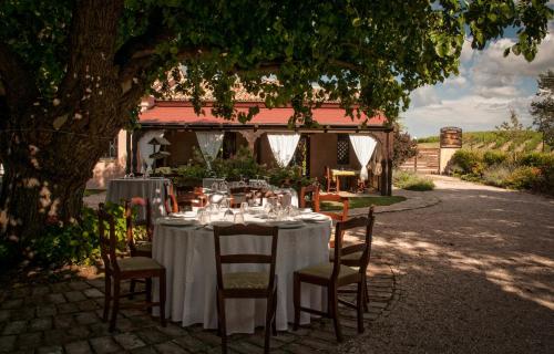 a table and chairs under a tree in a yard at Vittoria Il Graditempo Country House in Rosora