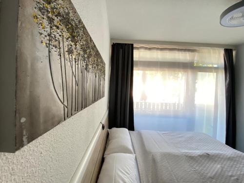 a bedroom with a white bed and a window at Studio 20qm mit Balkon und Innenpool - 22031 in Schluchsee