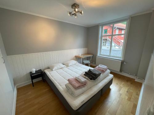 a bedroom with a bed with white sheets and a window at Fint, gratis parkering, med 20 min till Göteborg C in Kungälv