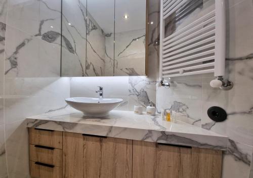 ein Bad mit einem Waschbecken und einem Spiegel in der Unterkunft Dream Home Veria in Veria