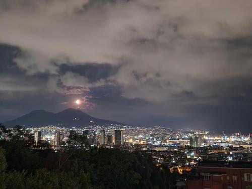 una vista de una ciudad por la noche con la luna en B&B La Veduta en Nápoles