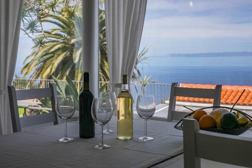 einen Tisch mit Weingläsern und einen Obstkorb in der Unterkunft Residencial Vista Panoramica in Santa Úrsula