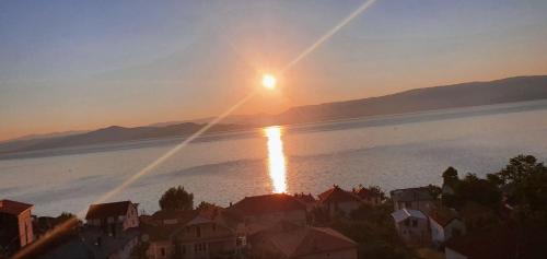 a sunset over a large body of water with houses at Vila Vista Magica Radozda in Struga
