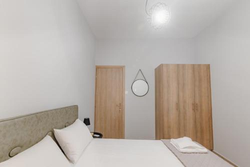 a bedroom with a bed and a mirror at THALASSA ALMYROS APARTMENTS in Almirón