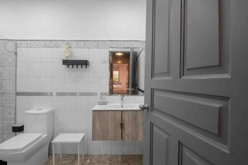 a bathroom with a toilet and a sink and a door at Escape 2BR Apartment in Gazcue Close to Colonial Zone in Santo Domingo