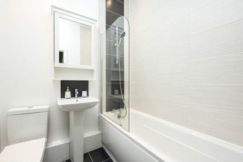 a white bathroom with a sink and a shower at Lovely 2 bedroom apartment in Central Bristol in Bristol
