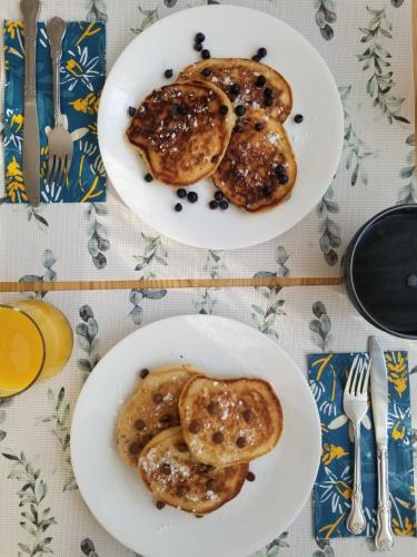 twee witte borden eten op een tafel bij Hill Road Manor Bed & Breakfast in Grand Falls -Windsor