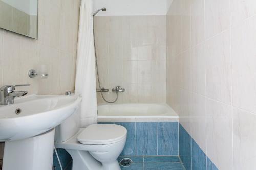 a bathroom with a toilet and a sink and a tub at THALASSA ALMYROS APARTMENTS in Almirón