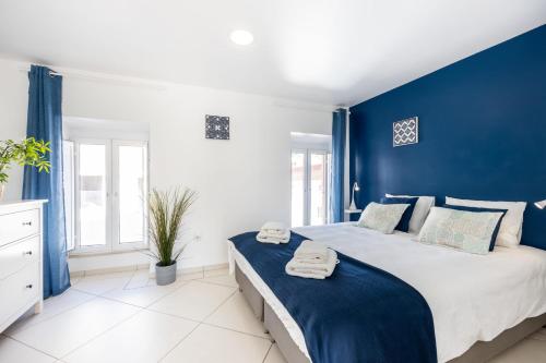 ein blau-weißes Schlafzimmer mit einem großen Bett in der Unterkunft Townhouse N7 - Albufeira in Albufeira