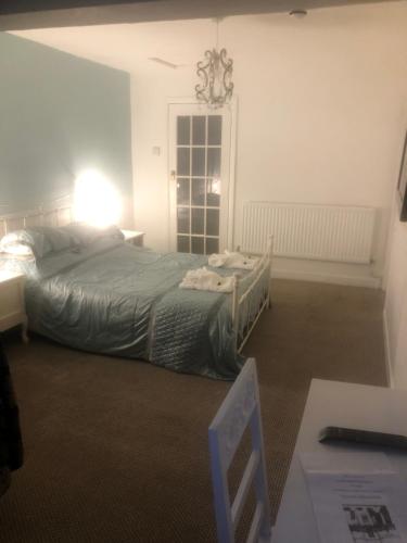 a bedroom with a bed and a table and a lamp at The Mayfair Hotel in Great Yarmouth
