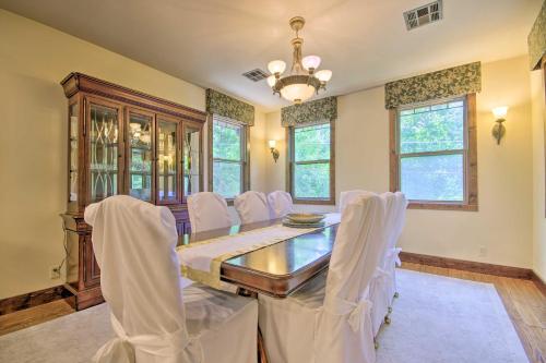 a dining room with a table and white chairs at Dragon Castle with Secret Passage, Dock, and Hot Tub in Camdenton