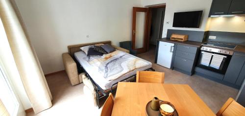Zimmer mit einem Bett und einer Küche mit einem Tisch in der Unterkunft Zweizimmer-Wohnung mit Parkgarage in Naturns