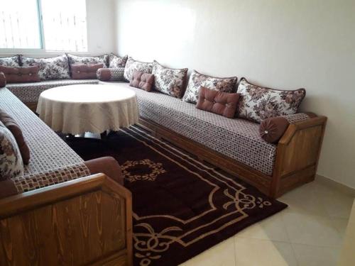 a living room with a couch and a table at Appt à plage sidi Rahal in Sidi Rahal