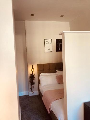 a bedroom with a bed and a light on the wall at 'Fairfield' at stayBOOM in Lancaster