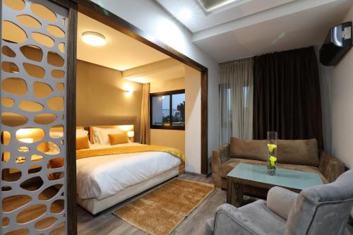 Silver Suites Hotel & Spa في الدار البيضاء: غرفة نوم بسرير واريكة وطاولة