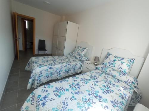 a bedroom with two beds with blue and white sheets at Palmeiro in Jove